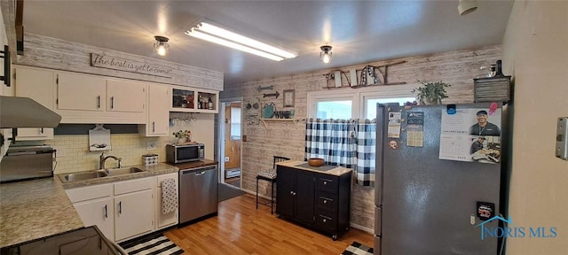 kitchen featuring white cabinetry, sink, light hardwood / wood-style flooring, and stainless steel appliances