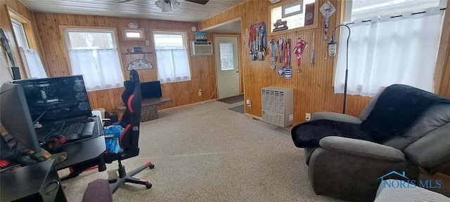 home office featuring ceiling fan, light colored carpet, wooden walls, and an AC wall unit