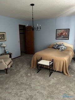 bedroom featuring carpet flooring, a textured ceiling, and a chandelier