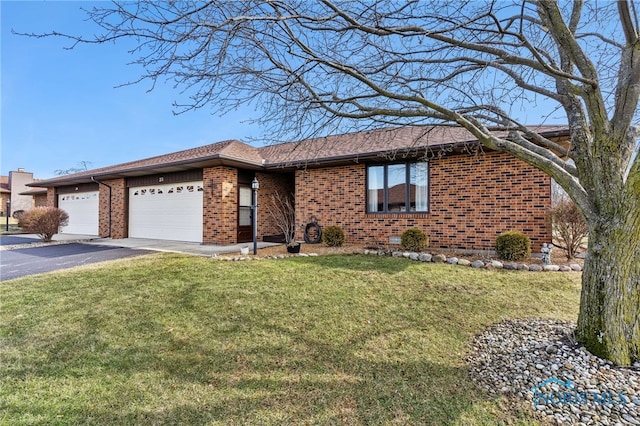 single story home featuring driveway, a front lawn, and brick siding