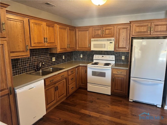 kitchen with white appliances, dark hardwood / wood-style flooring, sink, and backsplash