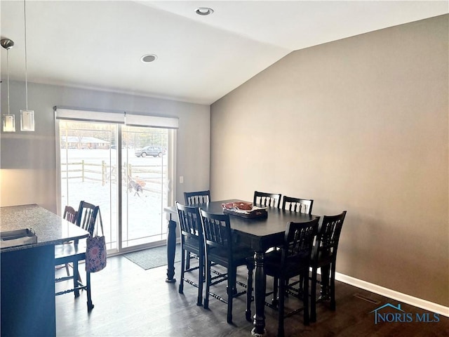 dining space with lofted ceiling and dark hardwood / wood-style floors