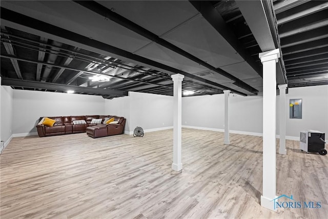 basement featuring hardwood / wood-style flooring and electric panel