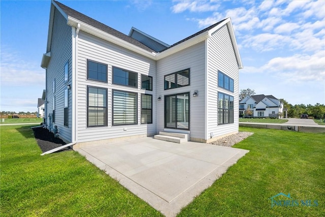 back of house with a patio and a yard