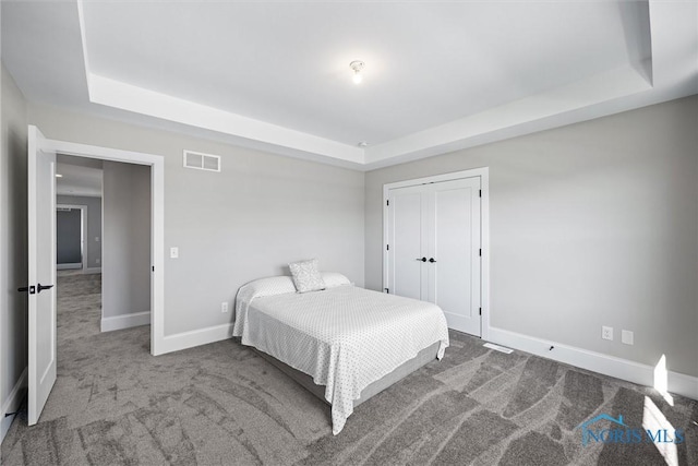 bedroom featuring carpet floors and a tray ceiling