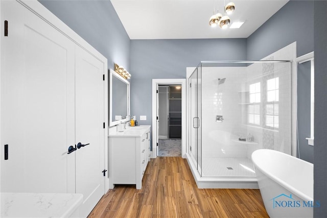 bathroom with independent shower and bath, hardwood / wood-style floors, and vanity