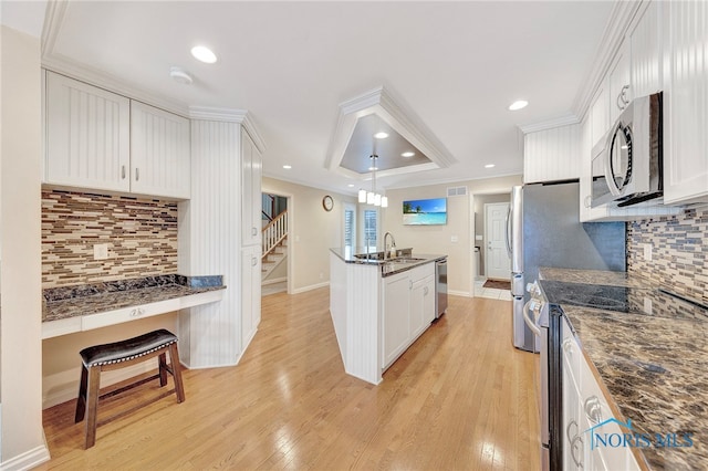 kitchen featuring crown molding, light wood-type flooring, white cabinets, and appliances with stainless steel finishes