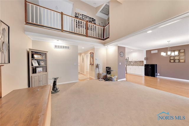 interior space featuring crown molding, a chandelier, and a high ceiling