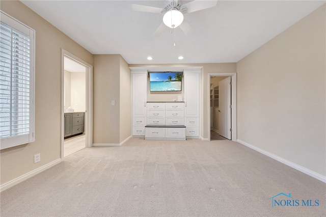 unfurnished bedroom with ceiling fan, connected bathroom, and light carpet