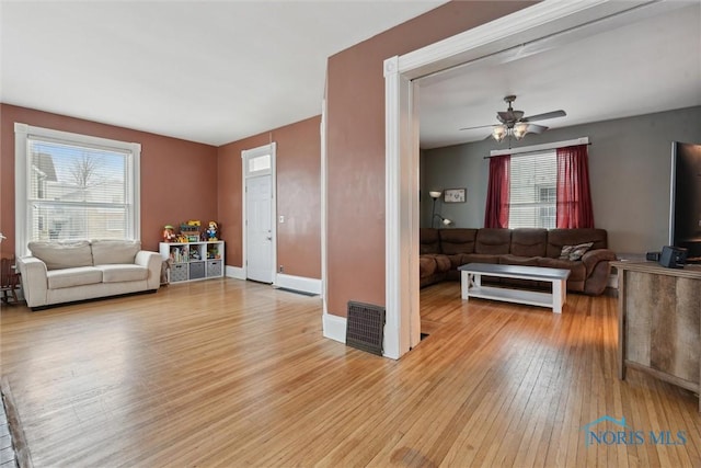 living room featuring ceiling fan and light hardwood / wood-style flooring