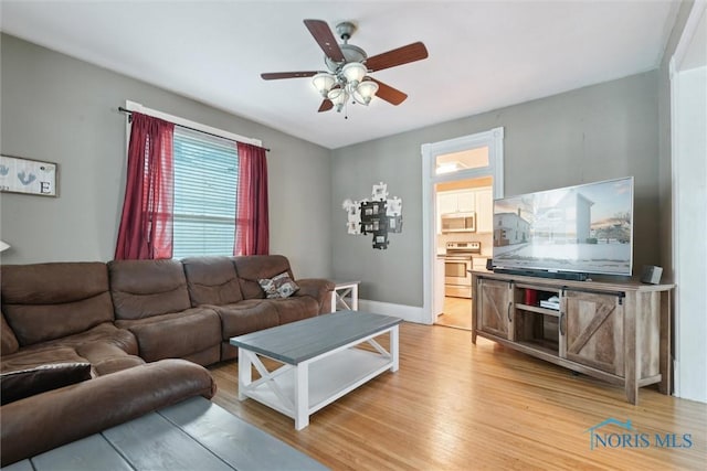 living room featuring light hardwood / wood-style floors and ceiling fan