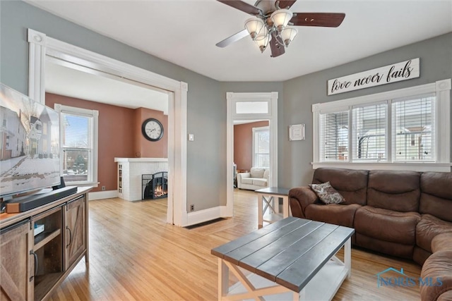 living room with ceiling fan, light hardwood / wood-style flooring, and a healthy amount of sunlight