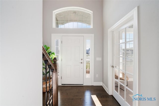 foyer with a high ceiling and dark wood-type flooring