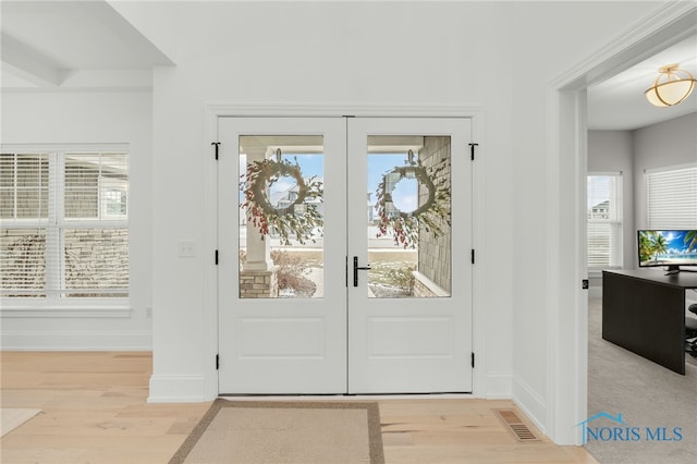 doorway with light wood-type flooring and french doors