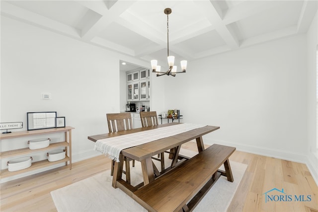 dining area featuring coffered ceiling, beam ceiling, a notable chandelier, and light wood-type flooring