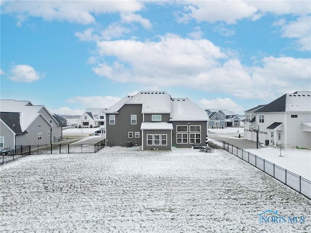 view of snow covered back of property