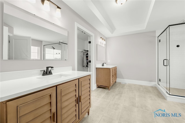 bathroom featuring tile patterned floors, walk in shower, vanity, and a raised ceiling