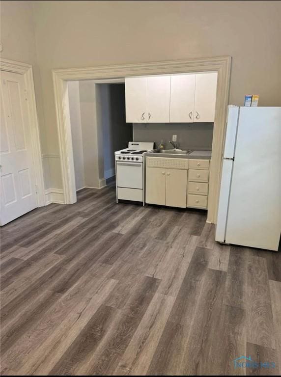 kitchen with sink, white appliances, white cabinets, and dark hardwood / wood-style floors