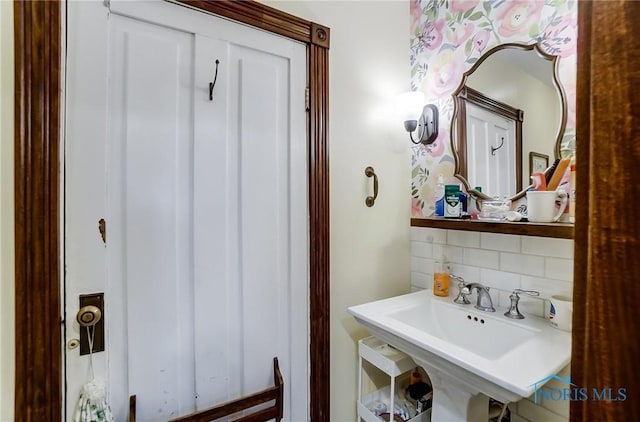 bathroom with tasteful backsplash and sink