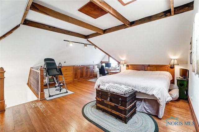 bedroom featuring light wood-type flooring and vaulted ceiling with beams