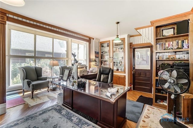 home office featuring hardwood / wood-style flooring, built in features, and crown molding