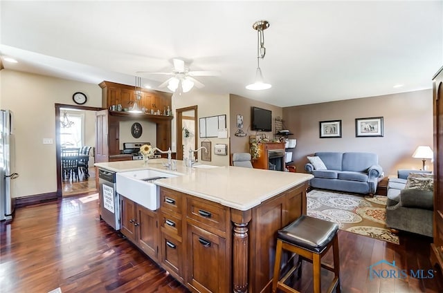 kitchen featuring sink, white refrigerator, a kitchen island with sink, and ceiling fan