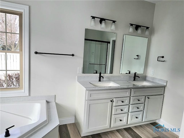 bathroom featuring a tub to relax in, wood-type flooring, and vanity