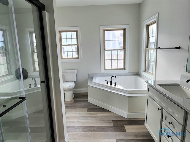 full bathroom with toilet, shower with separate bathtub, hardwood / wood-style floors, and vanity