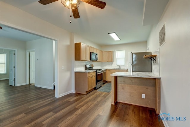 kitchen featuring dark hardwood / wood-style floors, stainless steel appliances, backsplash, ceiling fan, and light brown cabinets