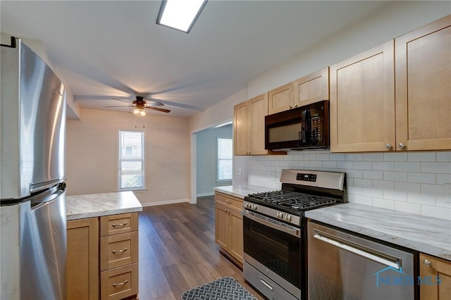 kitchen featuring stainless steel appliances, light brown cabinetry, ceiling fan, and tasteful backsplash