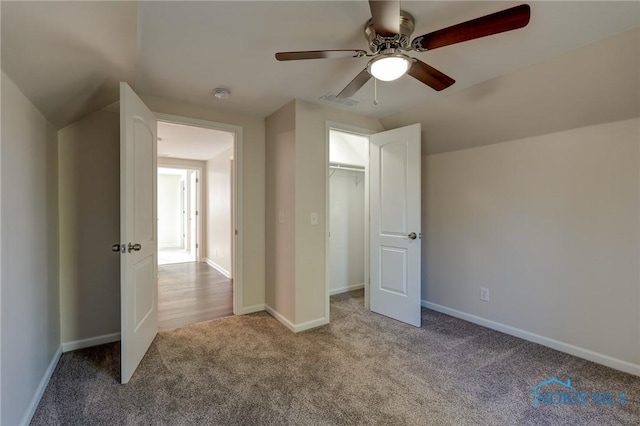 unfurnished bedroom with vaulted ceiling, a closet, ceiling fan, and light carpet