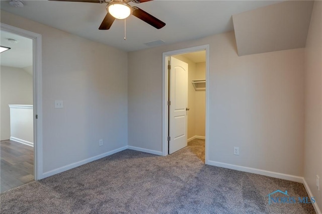 unfurnished bedroom with light colored carpet, ceiling fan, and a spacious closet