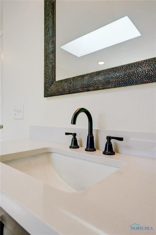 interior details featuring vanity and a skylight