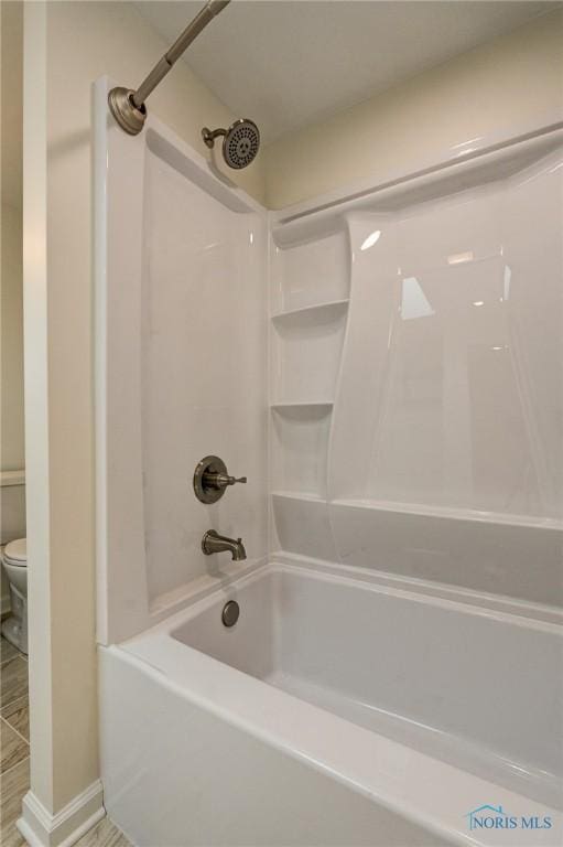 bathroom with tub / shower combination and toilet