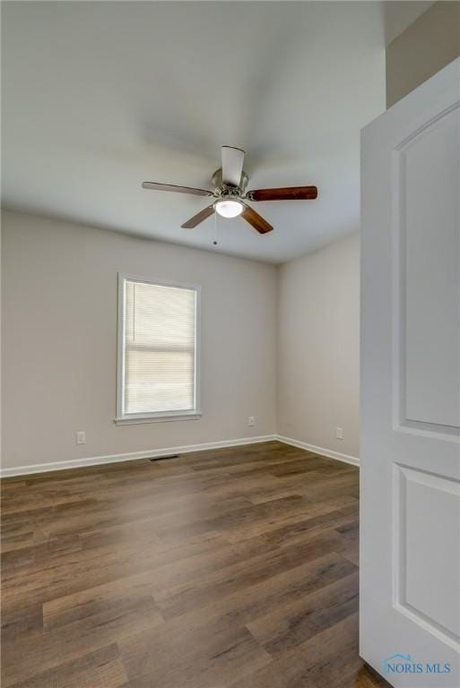 spare room with ceiling fan and dark hardwood / wood-style flooring