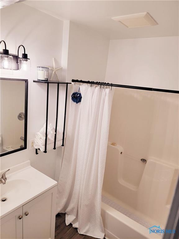 bathroom with vanity, hardwood / wood-style flooring, and shower / bath combo with shower curtain