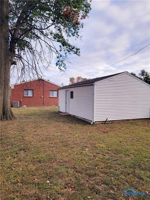 view of side of property with cooling unit and a yard