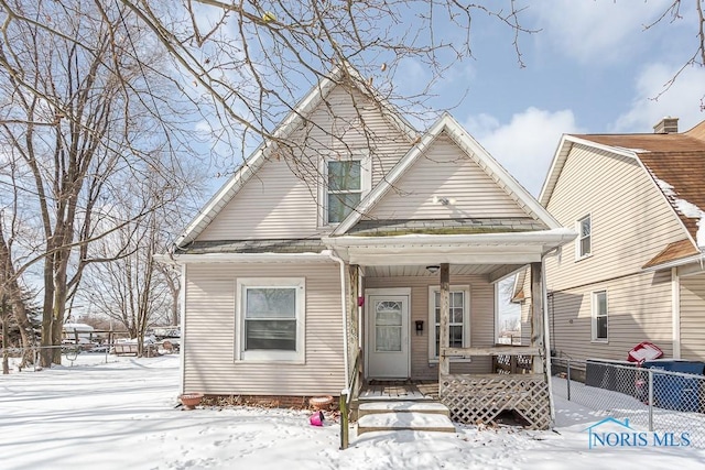 view of front of home with covered porch and fence