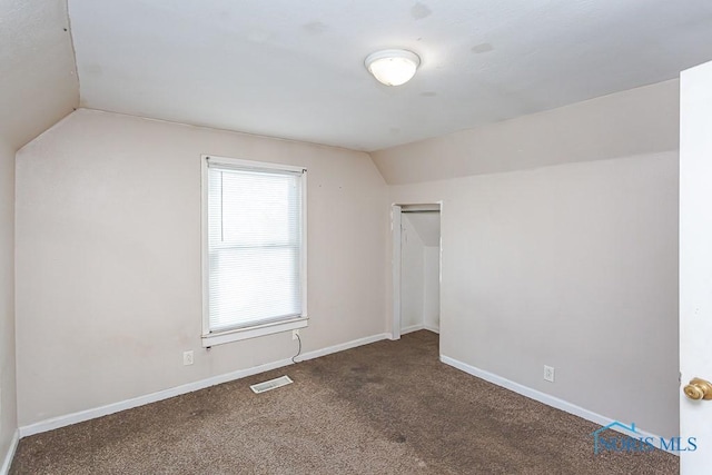 additional living space with lofted ceiling, carpet, baseboards, and visible vents