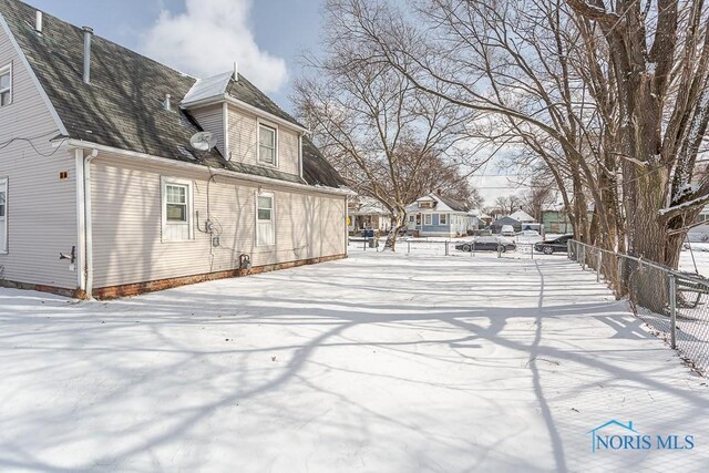 exterior space with roof with shingles and fence