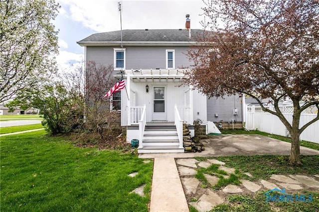 back of house featuring a pergola, a patio, and a lawn