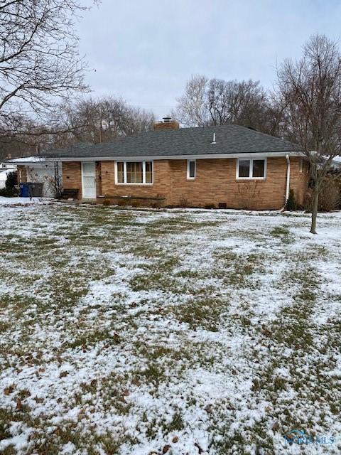 view of snow covered back of property