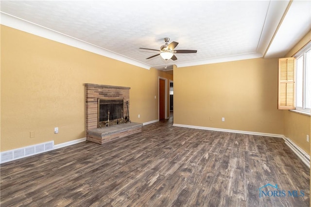 unfurnished living room with ceiling fan, a fireplace, ornamental molding, and dark hardwood / wood-style flooring