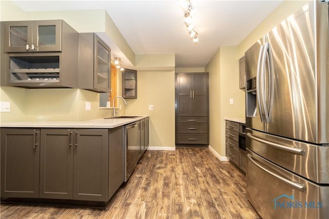 kitchen with gray cabinets, appliances with stainless steel finishes, sink, and dark hardwood / wood-style floors