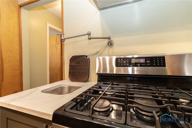 kitchen featuring light stone counters and gas range