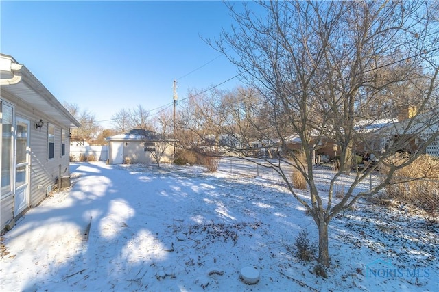 snowy yard featuring an outbuilding