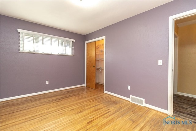 unfurnished bedroom featuring a closet and light wood-type flooring