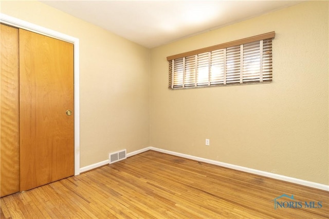 unfurnished bedroom featuring hardwood / wood-style flooring and a closet