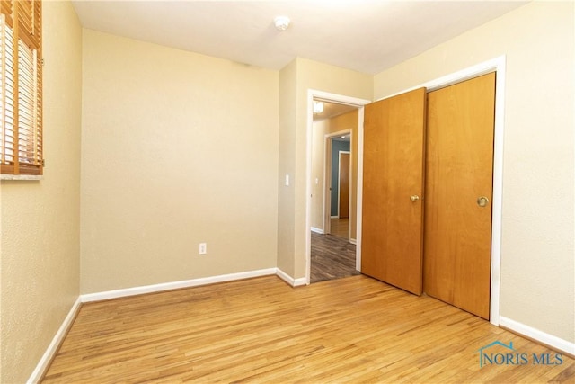 unfurnished bedroom with light hardwood / wood-style floors and a closet