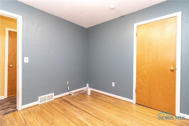 spare room featuring wood-type flooring